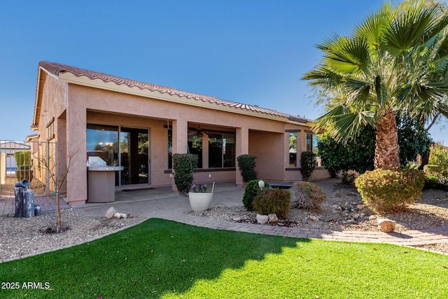 rear view of property featuring a lawn and a patio