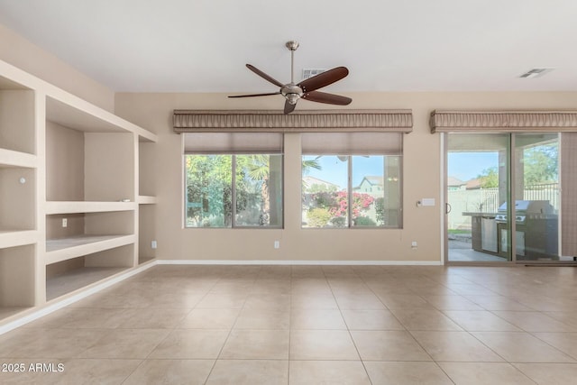 empty room with ceiling fan, light tile patterned floors, and built in features