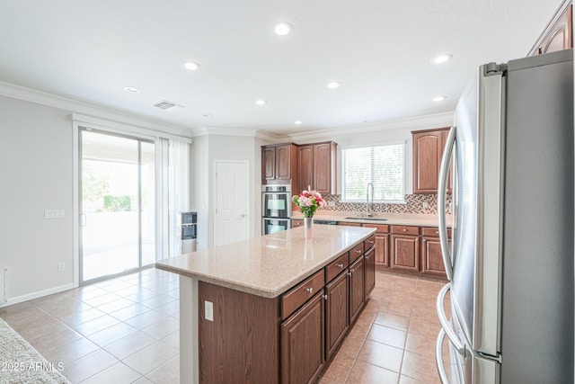 40232 W Marion May Ln, Maricopa, AZ 85138 - kitchen with appliances with stainless steel finishes, a sink, a kitchen island, decorative backsplash, and light tile patterned flooring