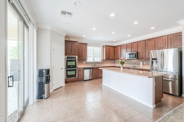 40232 W Marion May Ln, Maricopa, AZ 85138 - kitchen with stainless steel appliances, crown molding, tasteful backsplash, light countertops, and a sink