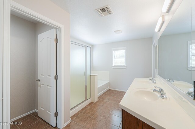 40232 W Marion May Ln, Maricopa, AZ 85138 - bathroom featuring tile patterned floors, a garden tub, a stall shower, double vanity, and baseboards