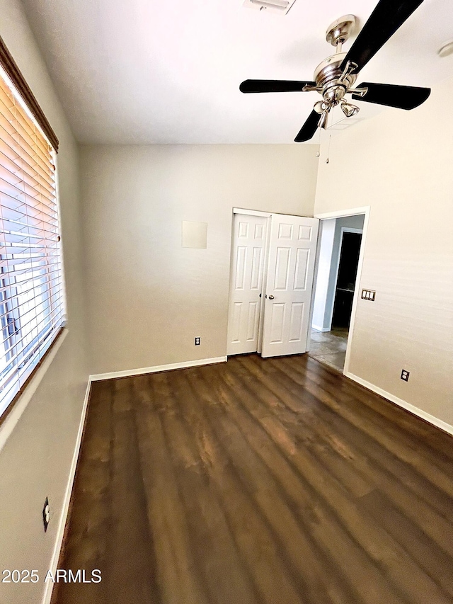 5749 S 247th Dr, Buckeye, AZ 85326 - unfurnished bedroom featuring baseboards, dark wood-type flooring, a closet, ceiling fan, and vaulted ceiling