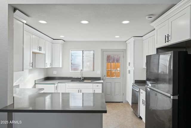 kitchen with sink, white cabinets, fridge, light tile patterned floors, and kitchen peninsula