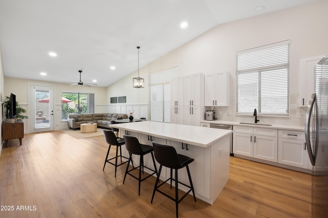 1748 E Cortez Dr, Gilbert, AZ 85234 - kitchen featuring a breakfast bar area, a center island, light countertops, white cabinetry, and a sink