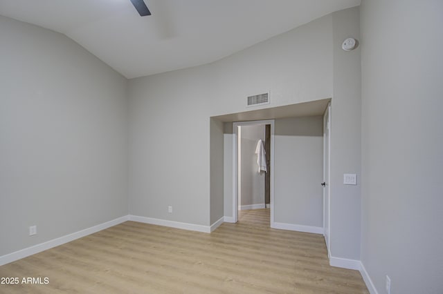 unfurnished room with ceiling fan, vaulted ceiling, and light wood-type flooring