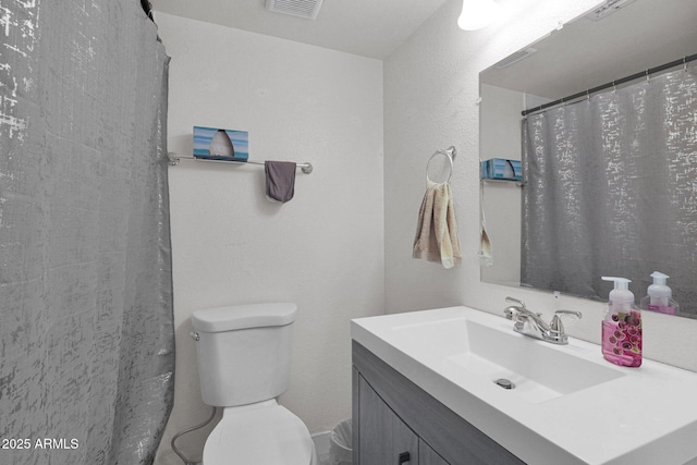 bathroom with toilet, vanity, and a shower with curtain