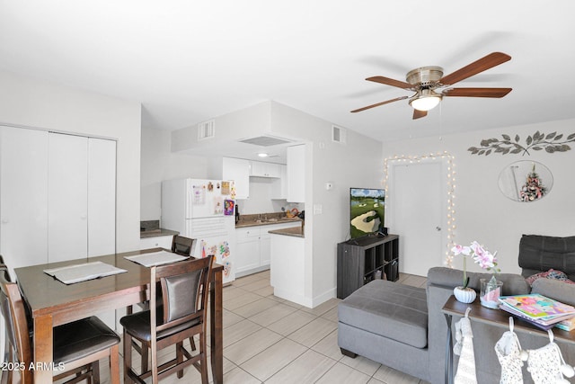 tiled dining space featuring ceiling fan