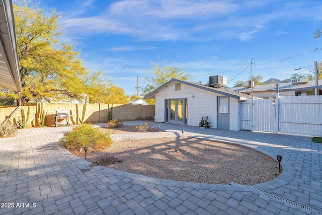 back of property with central air condition unit and a patio