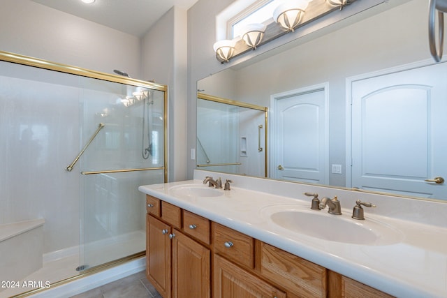 full bathroom with double vanity, a stall shower, tile patterned flooring, and a sink