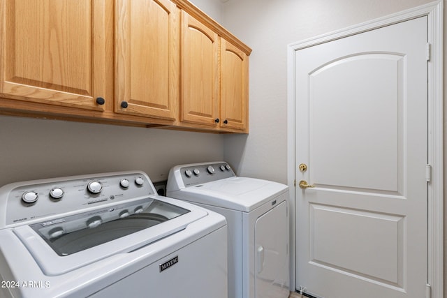 washroom featuring cabinet space and washing machine and clothes dryer