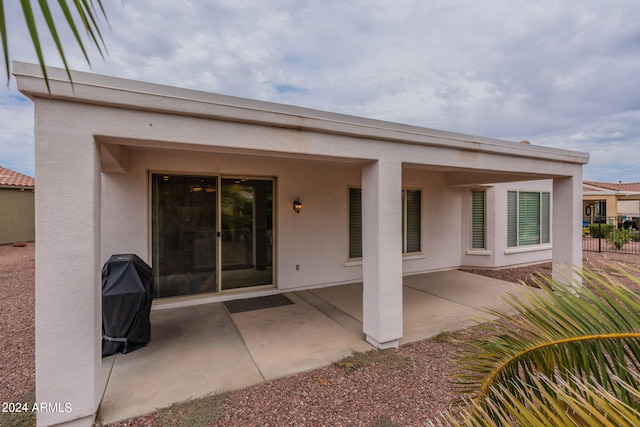 back of house featuring a patio area, fence, and stucco siding