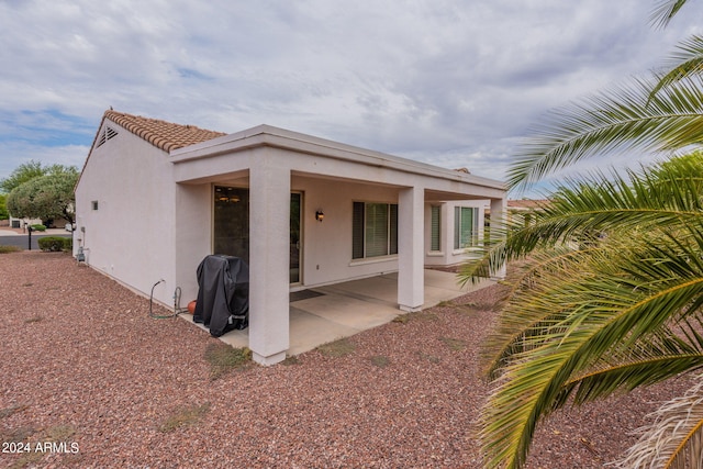 exterior space with a patio, a tile roof, and stucco siding