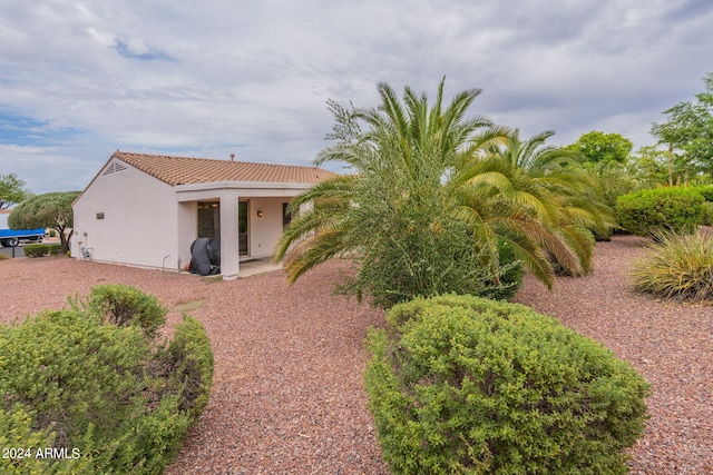 exterior space with a tiled roof and stucco siding