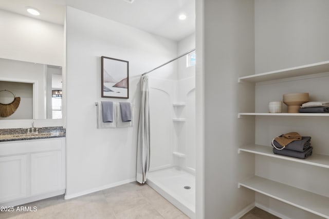 bathroom featuring a shower with shower curtain, tile patterned flooring, vanity, and baseboards