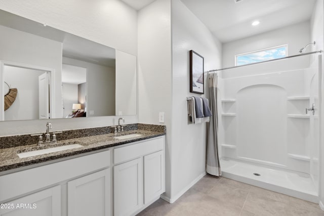 bathroom featuring double vanity, a sink, and a shower stall