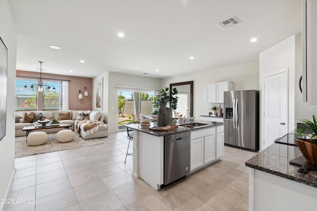 kitchen with visible vents, appliances with stainless steel finishes, white cabinets, and a sink