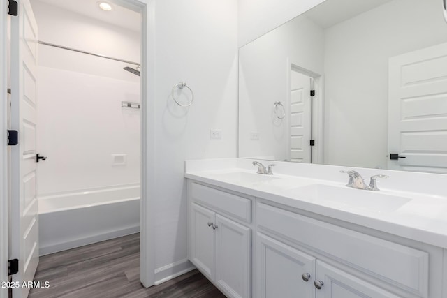 bathroom with hardwood / wood-style flooring, vanity, and shower / bathtub combination