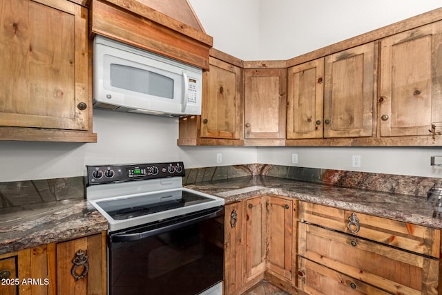 kitchen with electric range, white microwave, and brown cabinets