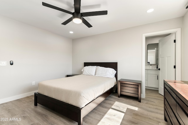 bedroom with ensuite bathroom, light wood-style flooring, recessed lighting, a ceiling fan, and baseboards