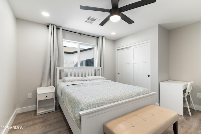 bedroom featuring recessed lighting, wood finished floors, visible vents, baseboards, and a closet