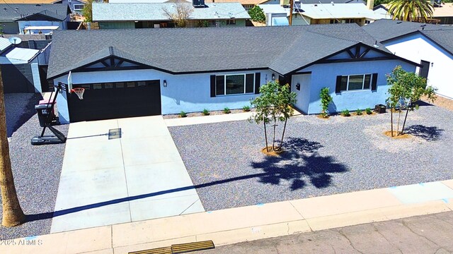 7014 E Latham St, Scottsdale, AZ 85257 - view of front of house with a garage, stucco siding, roof with shingles, a residential view, and concrete driveway
