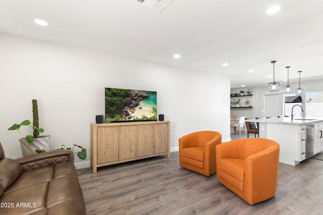 living room with recessed lighting, visible vents, and light wood-style flooring
