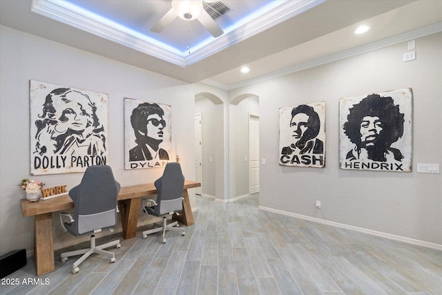 office area featuring visible vents, ornamental molding, a tray ceiling, wood finished floors, and ceiling fan