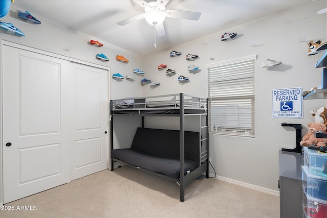 bedroom featuring baseboards, light carpet, a closet, and ceiling fan