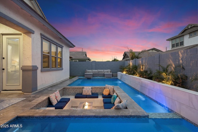 pool at dusk with a patio area, a fenced backyard, a fenced in pool, and an outdoor hangout area