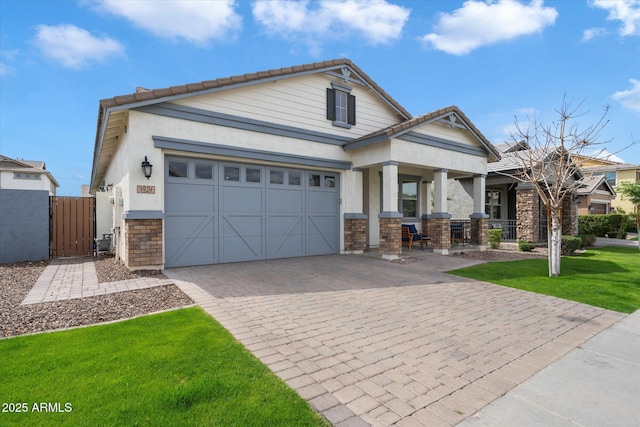 view of front facade featuring an attached garage, a front lawn, stone siding, a tile roof, and decorative driveway