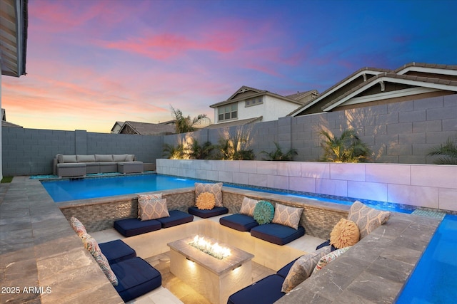 pool at dusk with a patio area, a fenced in pool, an outdoor living space with a fire pit, and a fenced backyard