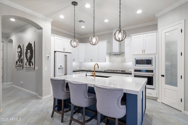 kitchen with a sink, crown molding, visible vents, and stainless steel appliances