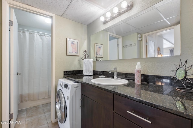 bathroom with tile patterned floors, a shower with curtain, a paneled ceiling, washer / dryer, and vanity