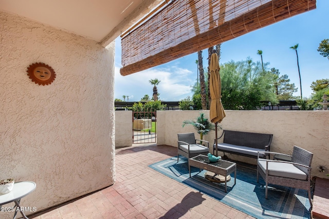 view of patio / terrace featuring a gate, outdoor lounge area, and fence