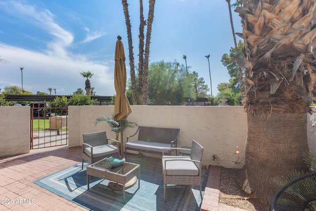 view of patio featuring a gate, fence, and an outdoor hangout area