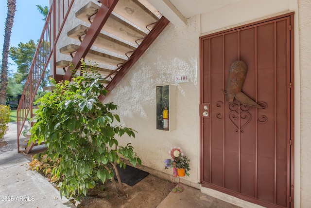 doorway to property featuring stucco siding