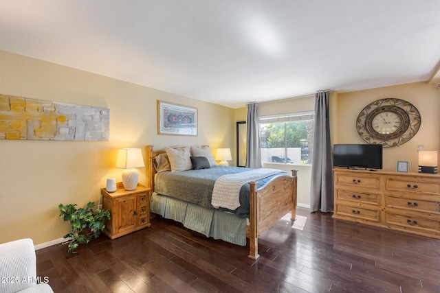 bedroom with baseboards and dark wood-style flooring