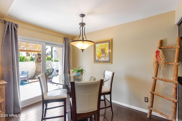 dining room featuring baseboards, dark wood-style flooring, and a textured wall