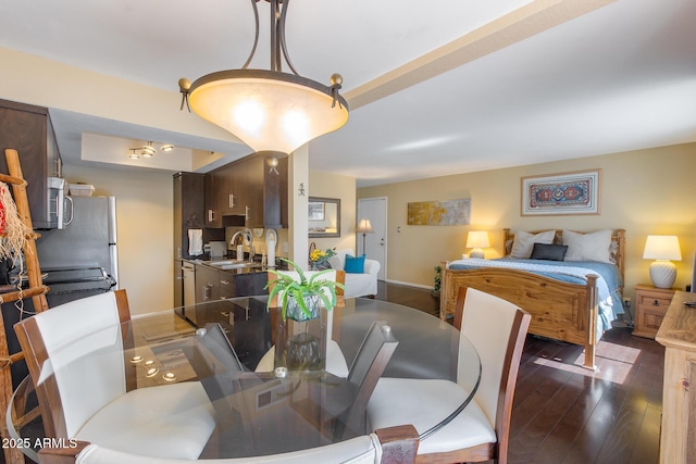 dining space featuring dark wood-style floors and baseboards