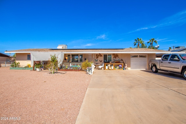 ranch-style house featuring covered porch and a garage