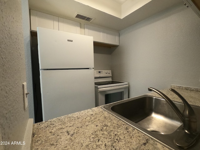 kitchen featuring sink, white appliances, and white cabinets