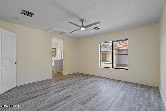 empty room featuring ceiling fan, plenty of natural light, and light wood-type flooring