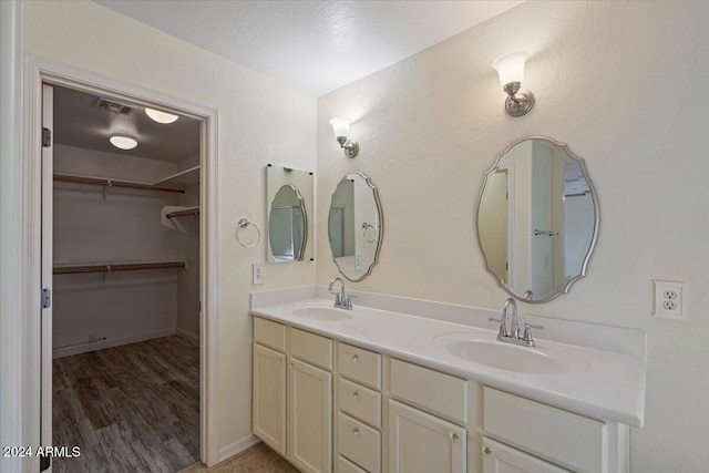 bathroom featuring wood-type flooring, vanity, and a textured ceiling