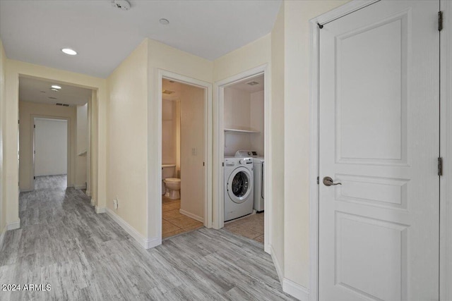 washroom featuring washer and clothes dryer and light wood-type flooring