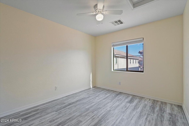 spare room with ceiling fan and light wood-type flooring