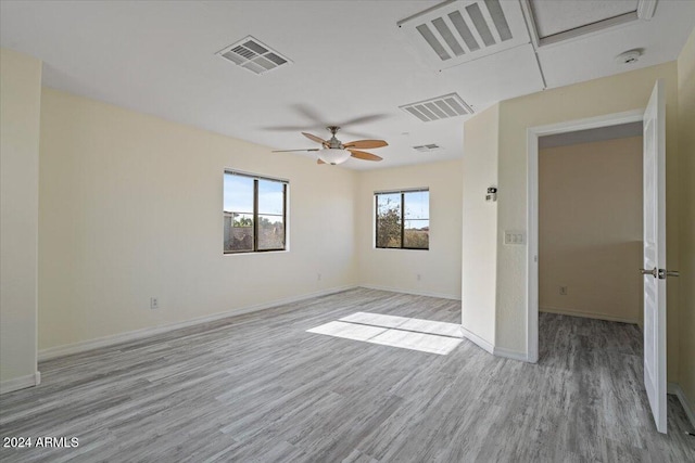 empty room with ceiling fan and light hardwood / wood-style flooring