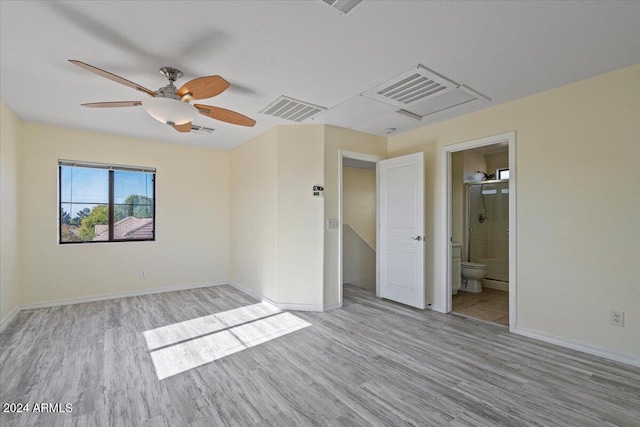 unfurnished bedroom with light wood-type flooring, ceiling fan, and connected bathroom