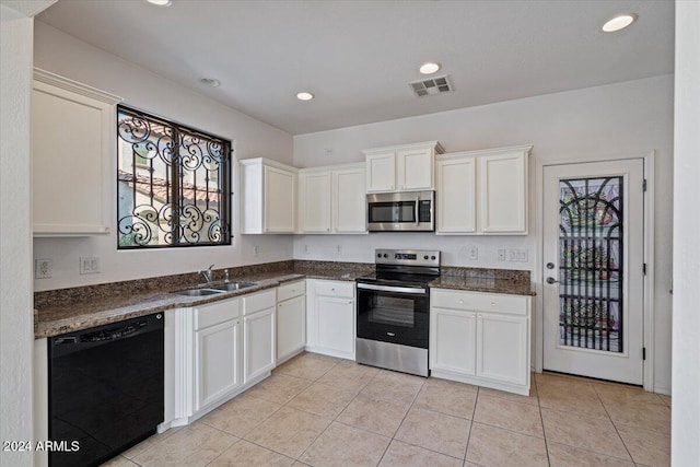 kitchen with sink, white cabinetry, light tile patterned floors, and stainless steel appliances