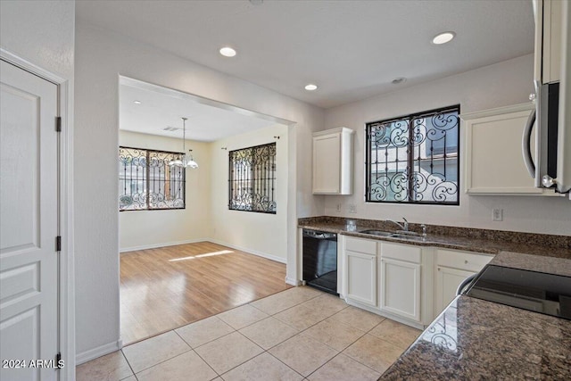 kitchen featuring light tile patterned flooring, black dishwasher, white cabinetry, and sink