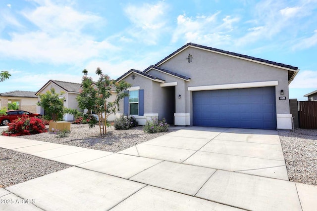 single story home featuring a garage, stucco siding, driveway, and fence
